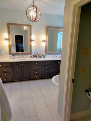Double vanity with quartz countertops and custom lighting in Sherman TX master bathroom